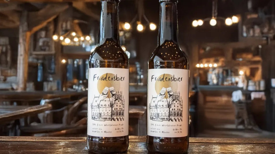 Zwei Flaschen Friedelnsbier stehen in einem rustikalen Wirtshaus mit stimmungsvoller Beleuchtung.